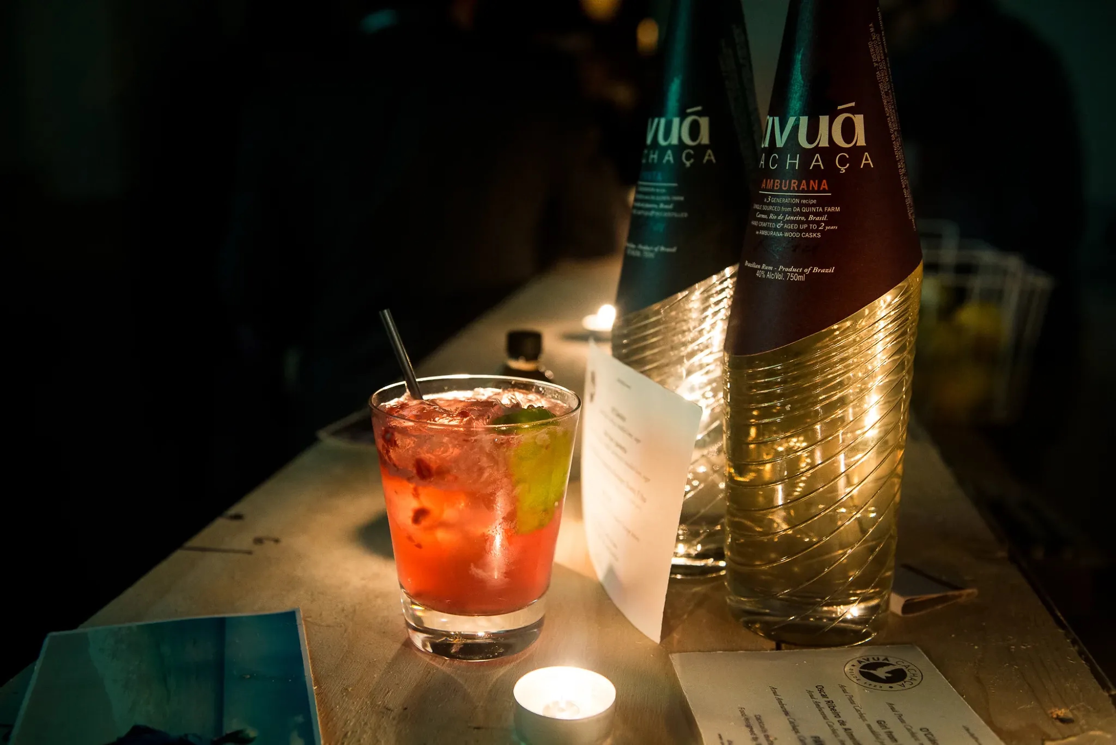 Avuá bottles and cocktails in warm bar light, from the brand’s photographic archive